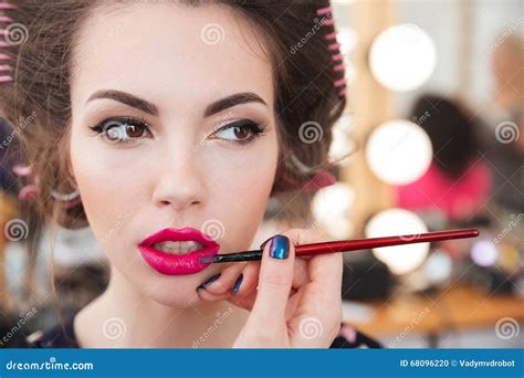 Makeup Artist Doing Makeup Applying Pink Lipstick Using Brush Stock