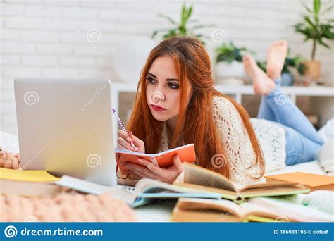 cute teen girl  homework  lying   bed  home distance learning stock image