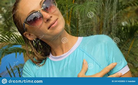 woman taking a shower in garden near hotel girl in blue swimsui stock