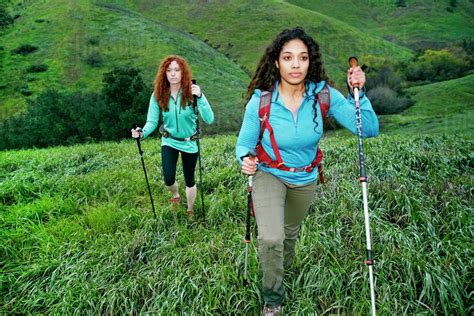 women hiking  walking sticks stock photo dissolve