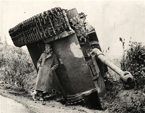 british soldier hiding from the rain under the german tank tiger during world war ii 1944
