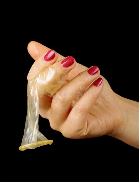female hand holding condom isolated on the black