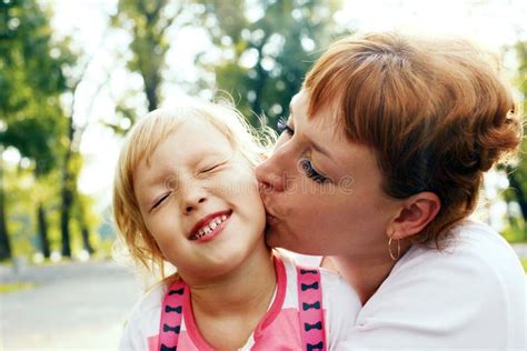 an affectionate mom kissing her little daughter stock image image of