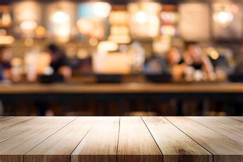 wooden table with blur background of coffee shop stock