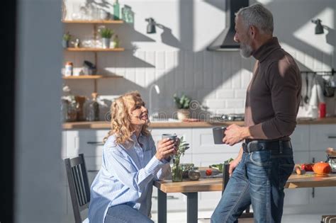 Mature Couple Having Morning Coffee Andtalking In The Kitchen Stock