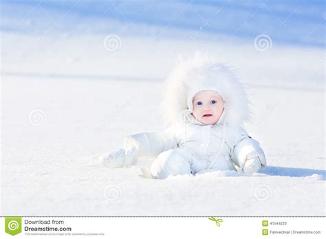 funny  baby playing  snow  sunny day stock photo image