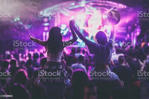 Back View Of Carefree Female Friends Having Fun On A Music Festival At