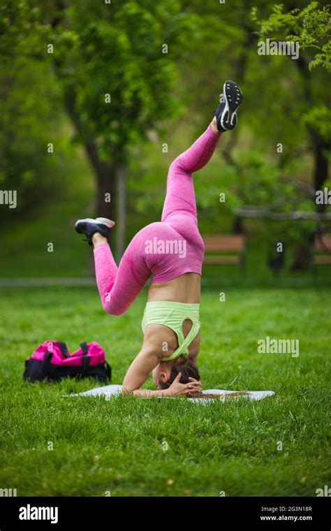 Athletic Fit Woman Doing Yoga Exercises Standing On Her Head In A Park
