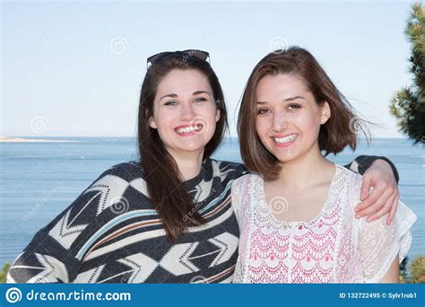 lesbian couple holding hugging each other on the beach coast stock