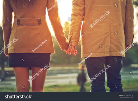 Happy Couple Holding Hands Looking In The Sunset Stock