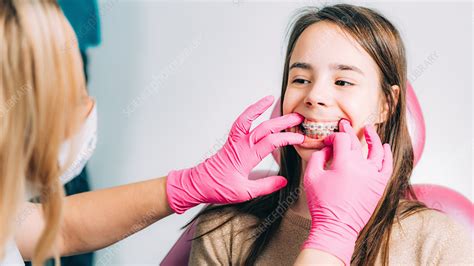 Orthodontist Fixing Girls Dental Braces Stock Image F024 1229