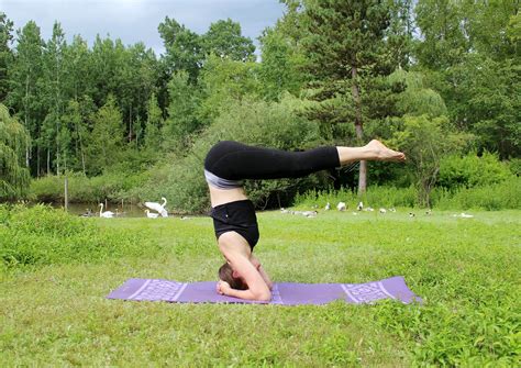 strong woman  supported headstand yoga pose outdoors high