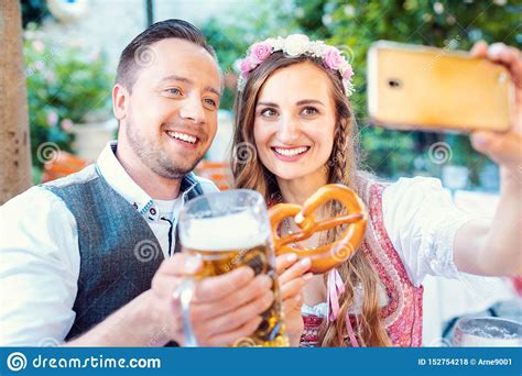 couple in german beer garden taking a selfie picture with