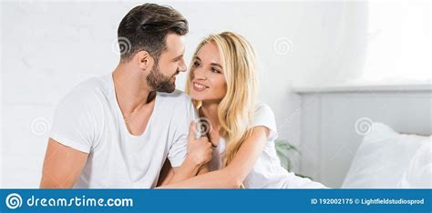 Shot Of Beautiful Couple In Pajamas Hugging On Bed At Home Stock Image