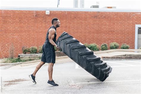 Strong And Fit African American Athlete Flipping A Tractor Tire By