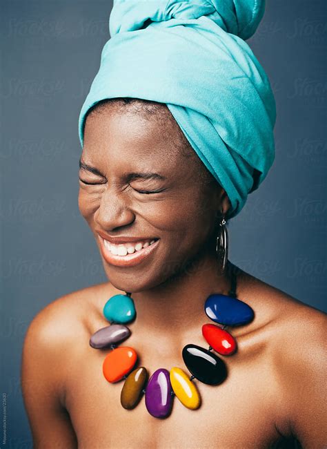 African Woman With A Turban On Her Head Laughing Out Loud By Stocksy