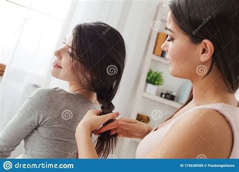 lesbian couple in bedroom at home sitting one woman making