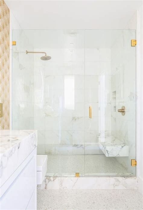a gold handle accents a seamless glass shower door opening to a