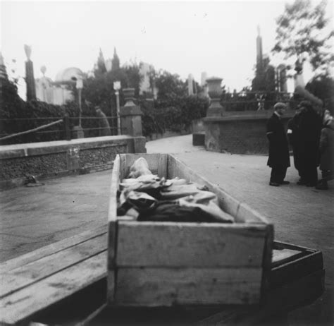a corpse lies in an open coffin awaiting burial in the warsaw ghetto
