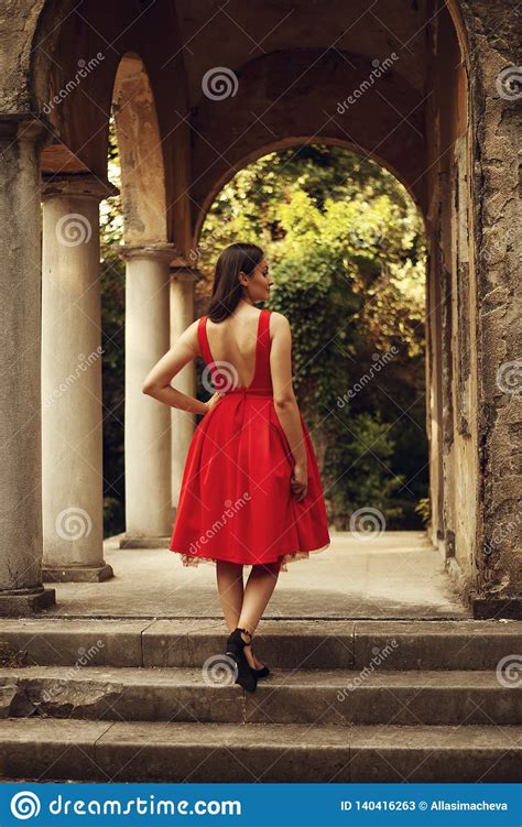 Portrait Of Beautiful Woman Wearing Red Classy Dress View From Behind