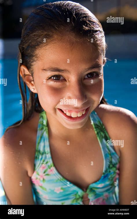 hermosa y pequeña niña latina en traje de baño en la piscina fotografía