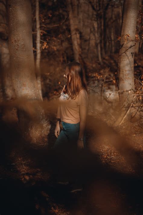 Woman In White T Shirt And Black Pants Standing In Forest Photo Free