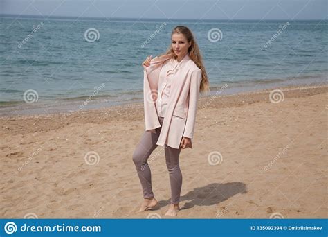 Beautiful Blonde Woman Walking On The Sandy Sea Beach