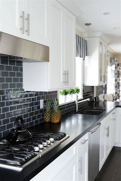 black honed granite countertop white cabinet subway backsplash tile dark floor black kitchen