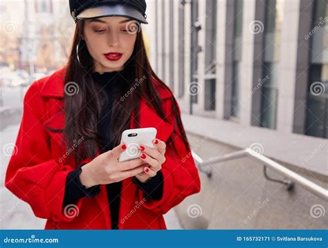 Unforgettable Glorious Woman In Black Cap Holds A White Cellphone And