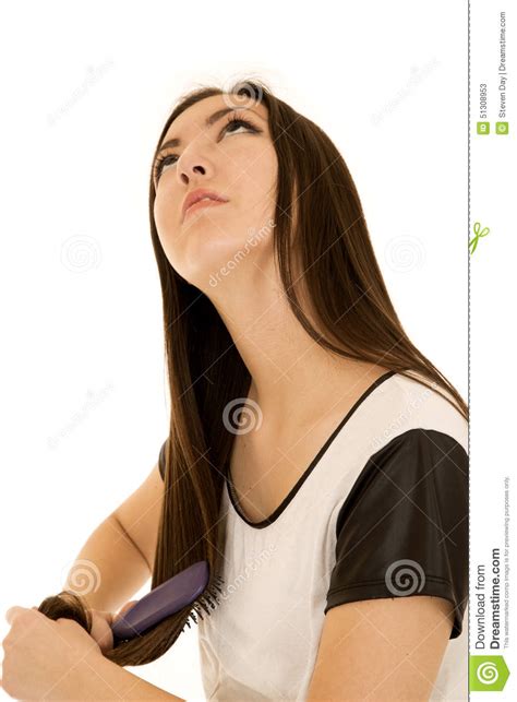 attractive asian teen brushing her hair looking up stock