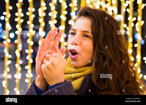 Girl Warming Up Her Hands In The Winter With Festive Background Stock