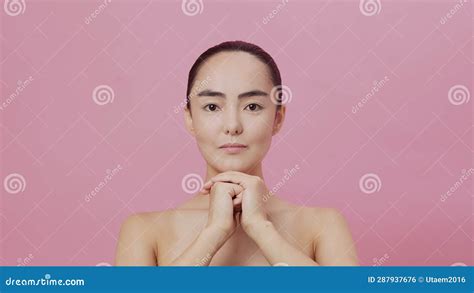 Young Attractive Asian Woman With Clean Skin Folding Her Hands Under