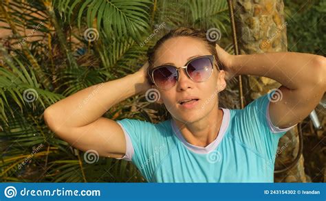 woman taking a shower in garden near hotel girl in blue swimsui stock