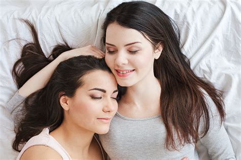 lesbian couple in bedroom at home lying top view sleeping smiling happy