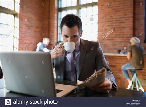 businessman drinking coffee reading newspaper coffee shop