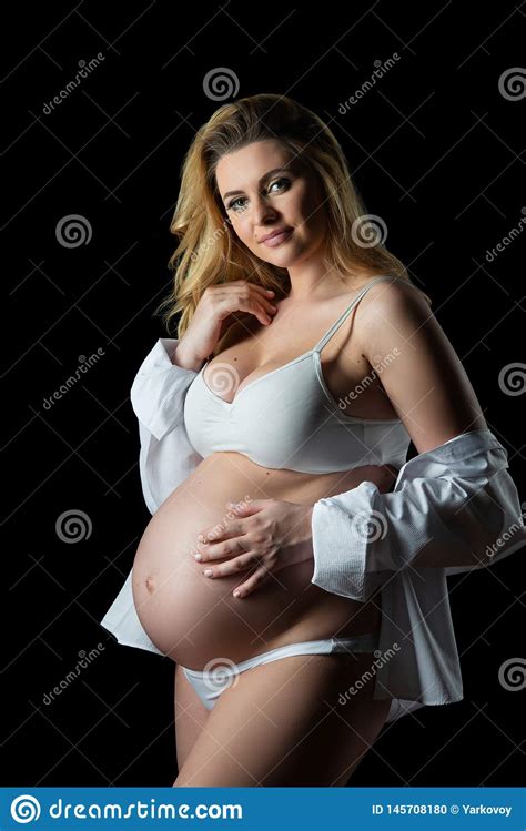 Mooie Blonde Zwangere Vrouw In Witte Kleren Op Een Zwarte