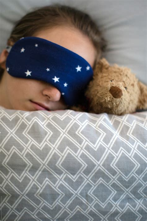 Teenage Girl Sleeping In Bed With Her Teddy Bear And A Sleep Mask With
