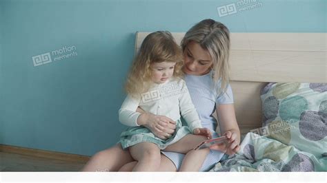 mother and her cute little daughter watching video on