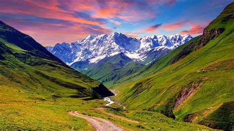 nature valley mountain river grazing green grass snowy peaks sky  red clouds