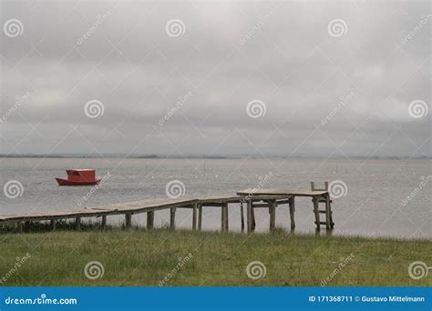 rode boot  het water en een wharf stock afbeelding image  visser groen
