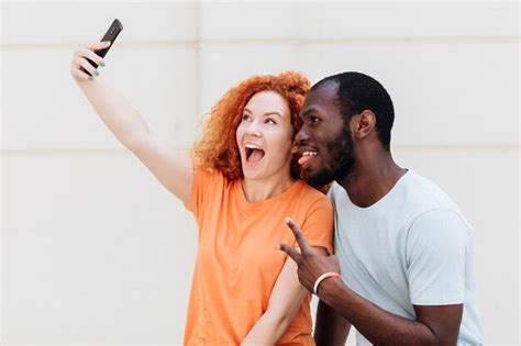 Free Photo Medium Shot Of Interracial Couple Taking A Selfie