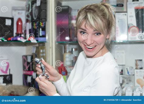 Beautiful Cute Girl Chooses A Sex Toy In An Adult Store Stock Image
