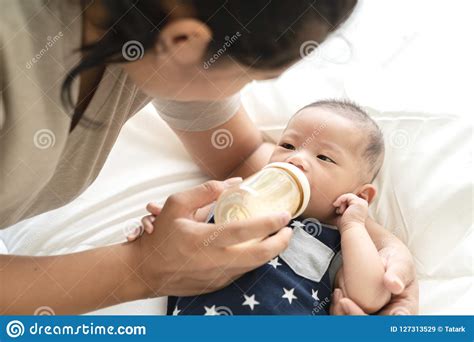 jonge spaanse baby  de aziatische consumptiemelk van de zuigelingsjongen van plastiek die van
