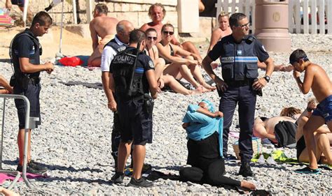 shocking moment armed police confront french woman wearing burkini on a beach world news