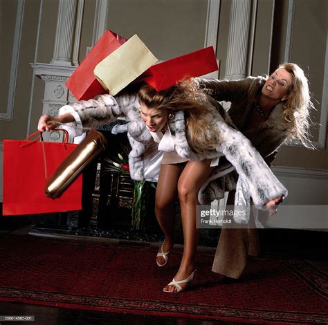 two women fighting with shopping bags indoors photo getty images
