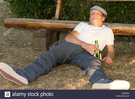 Alcoholic Passed Out On The Ground In A Park Lying With