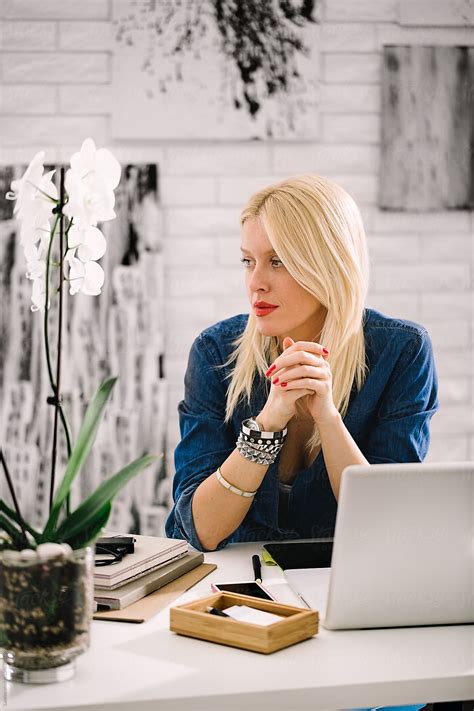 Blonde Businesswoman Sitting At Her Desk By Lumina