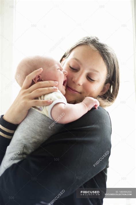 teenage girl holding  baby sister crying children kids stock