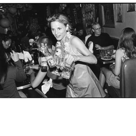 A Black And White Photo Of A Woman Holding Bottles In Her Hands At A Party
