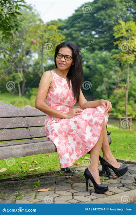 happy mature asian woman relaxing at the park outdoors imagen de